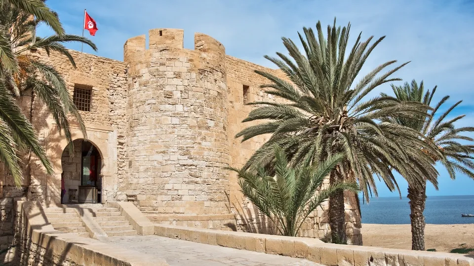 Scène de marché local à Djerba avec étals de fruits et poissons